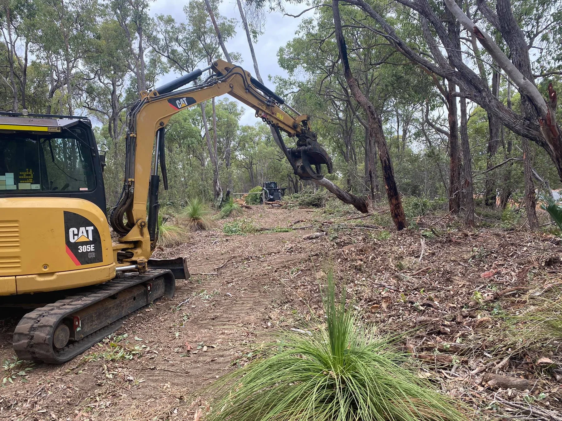 Excavator clearing bushland road access for land clearing in Western Australia